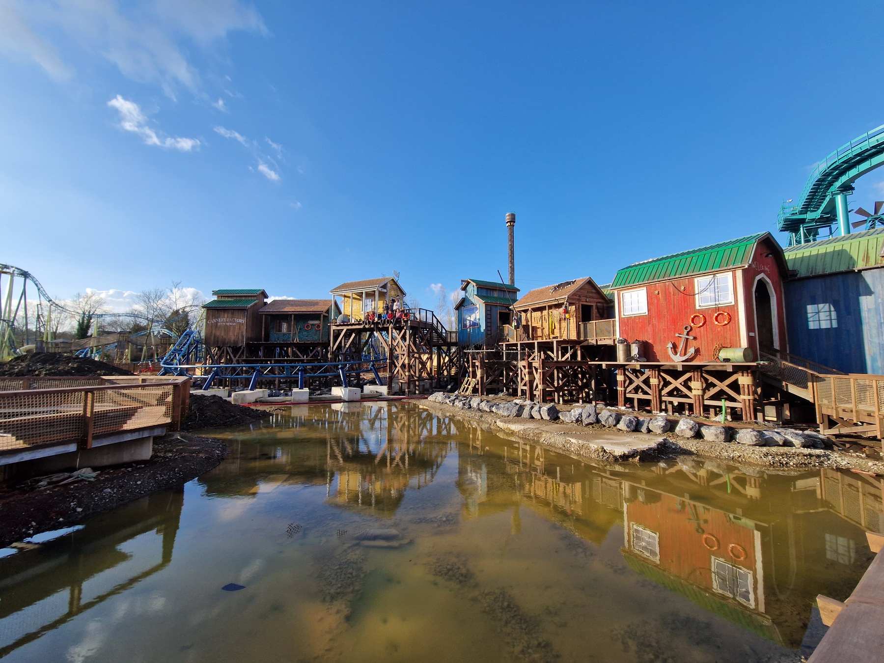 Village de cabanes sur pilotis de Dock World à Walibi, reflété dans le bassin