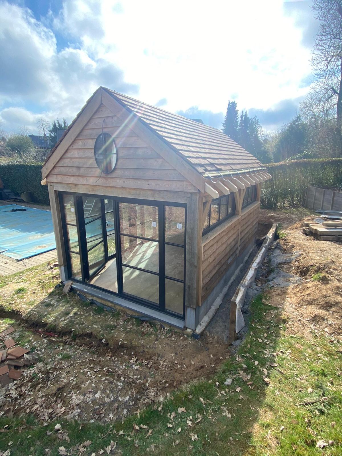 Pool house vitré à oeil-de-boeuf au bord de la piscine